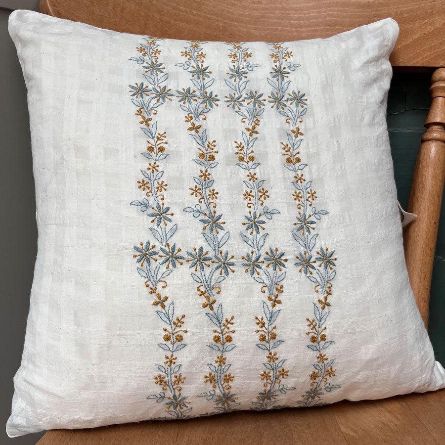 Golden bluebell Chikankari cushion cover featuring a delicate trailing hand embroidery in golden yellow and light blue