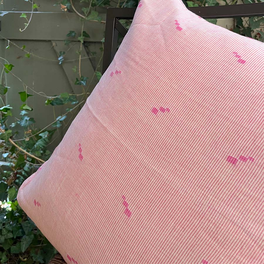 Pink Jamdani cushion cover with a subtle handwoven motif.