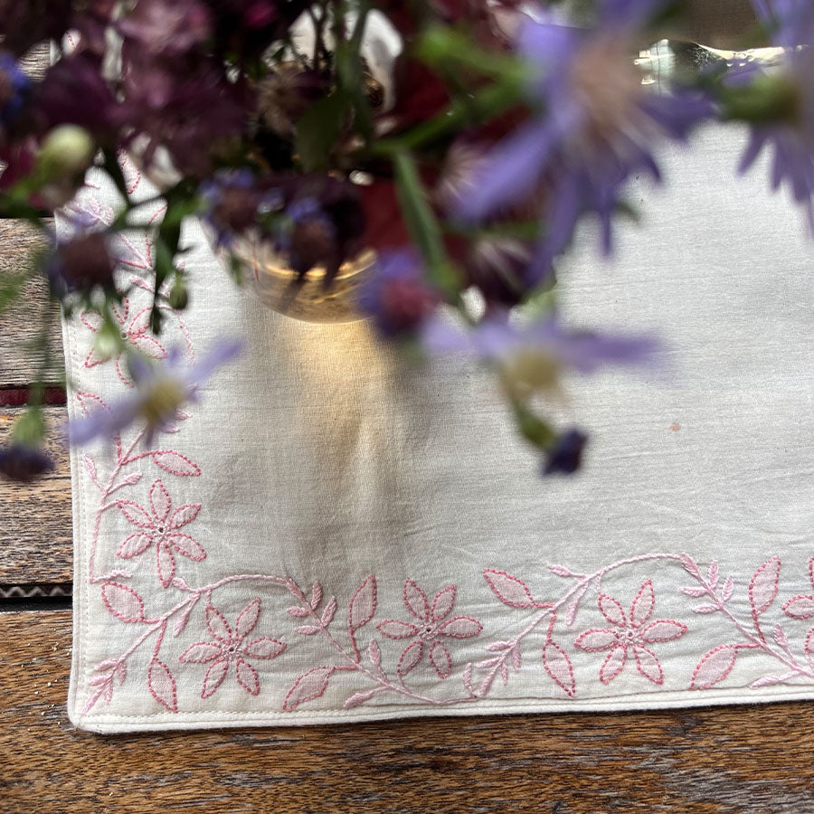 Rosette Chikankari placemats with a blurred flower arrangement in the foreground