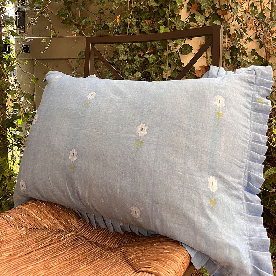 Sapphire blue Jamdani cushion cover with handwoven floral motifs and soft ruffle edges