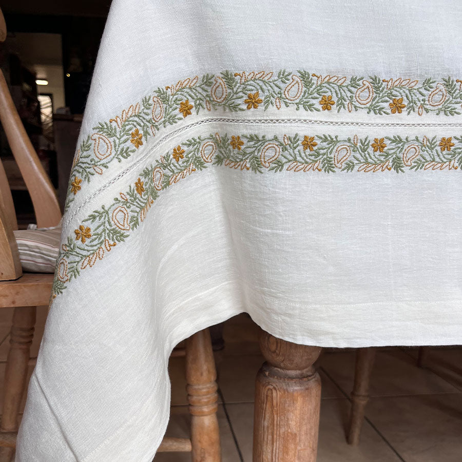 Hand-embroidered Baagh Chikankari tablecloth on a wooden table