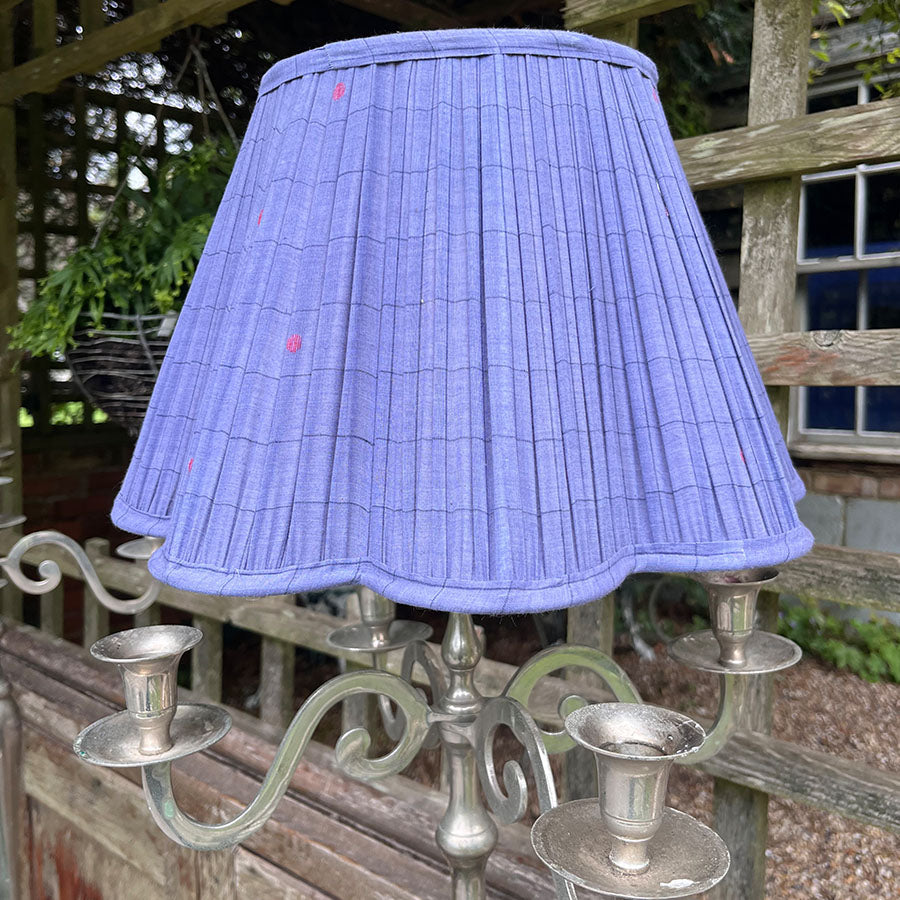 A deep blue Jamdani lampshade adorned with fine red motifs and scalloped edging.