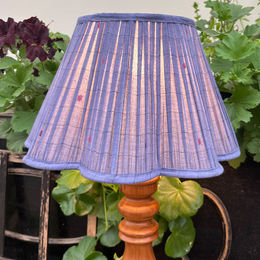 A deep blue Jamdani lampshade adorned with fine red motifs and scalloped edging.