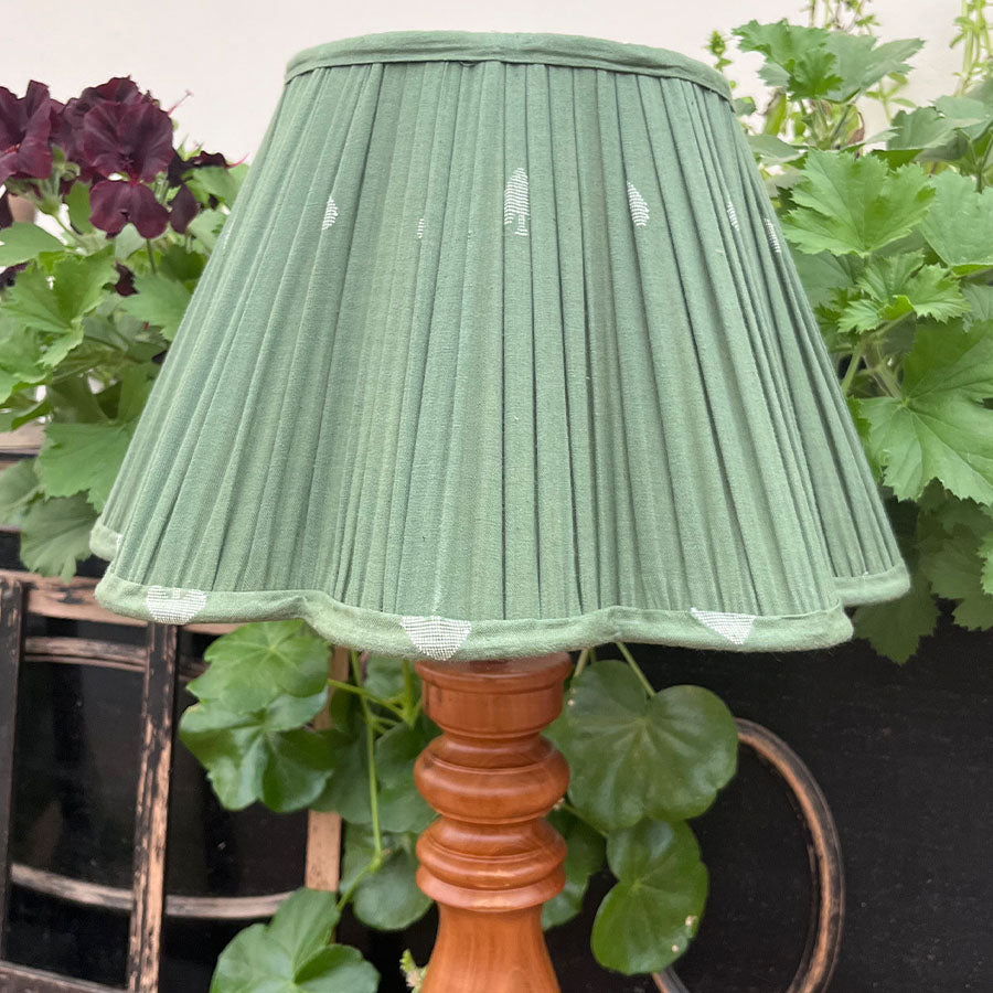 A soft sage green Jamdani lampshade woven with delicate white spade motifs