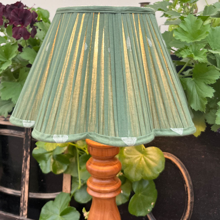A soft sage green Jamdani lampshade woven with delicate white spade motifs