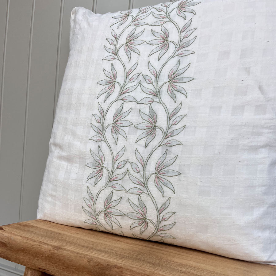 Saaya chikankari cushion cover with lotus bloom embroidery placed on a wooden stool