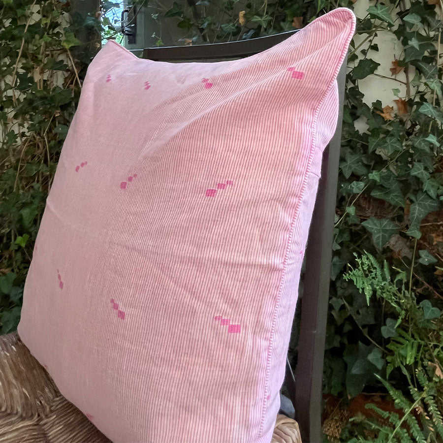 Pink Jamdani cushion cover with a subtle handwoven motif. 