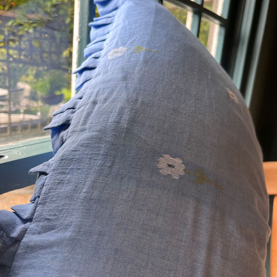 Sapphire blue Jamdani cushion cover with handwoven floral motifs and soft ruffle edges