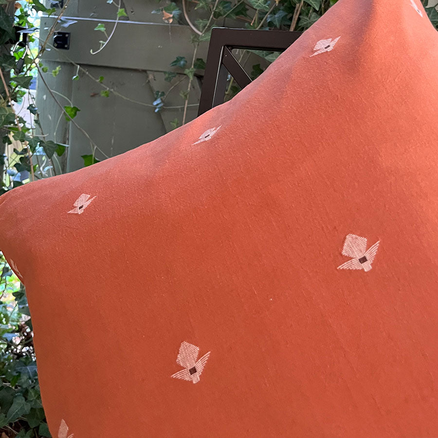 Close-up of Terracotta Jamdani cushion cover with white motifs