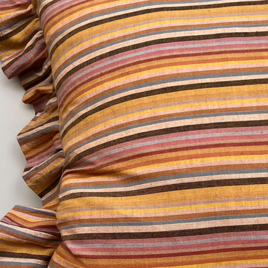Close-up of mustard yellow striped pillow cover with ruffled edged